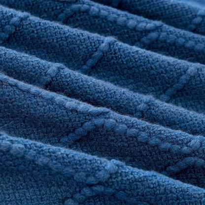Close-up of a textured blue cable-knit fabric with diagonal ribbed rows and a soft, plush surface.