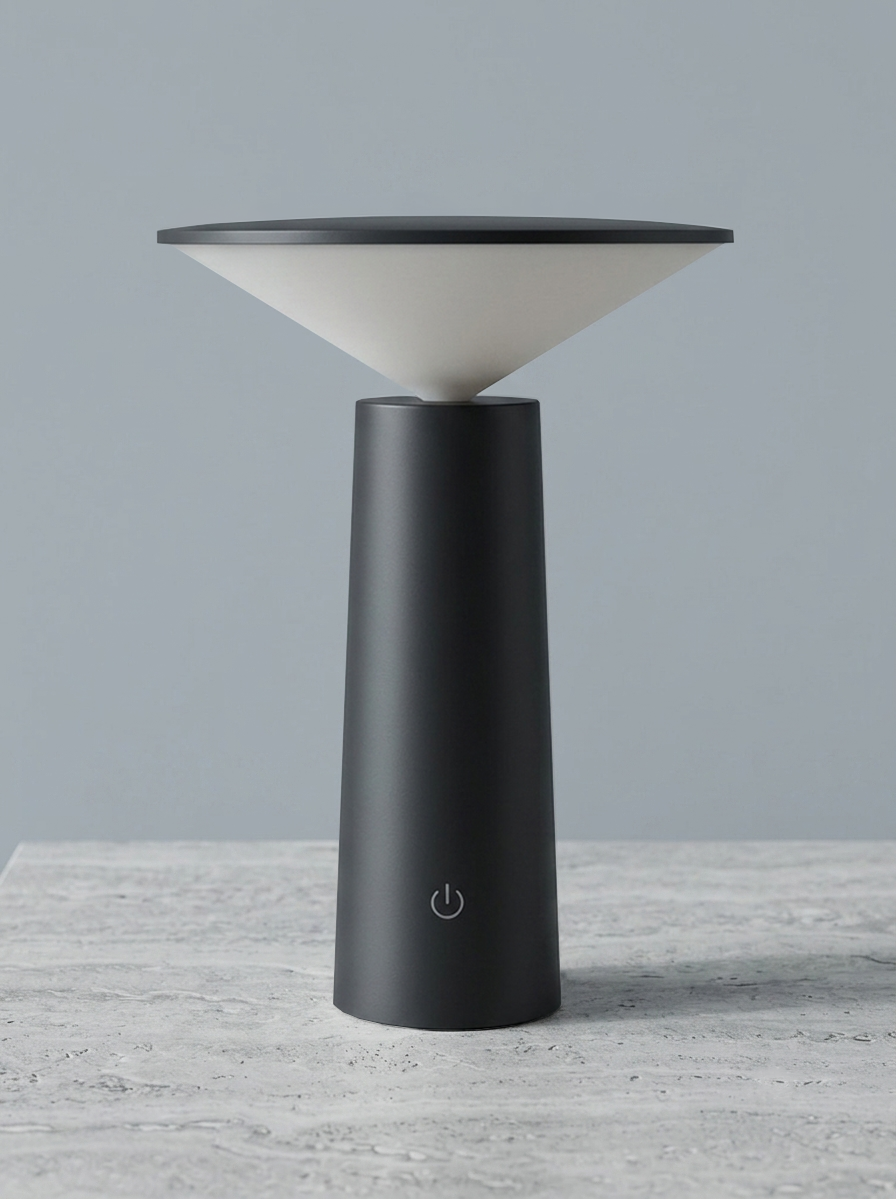 A modern Scandinavian Mushroom table lamp with a matte black cylindrical base and a conical shade made of off-white material, shown on a light gray stone surface against a solid gray background.