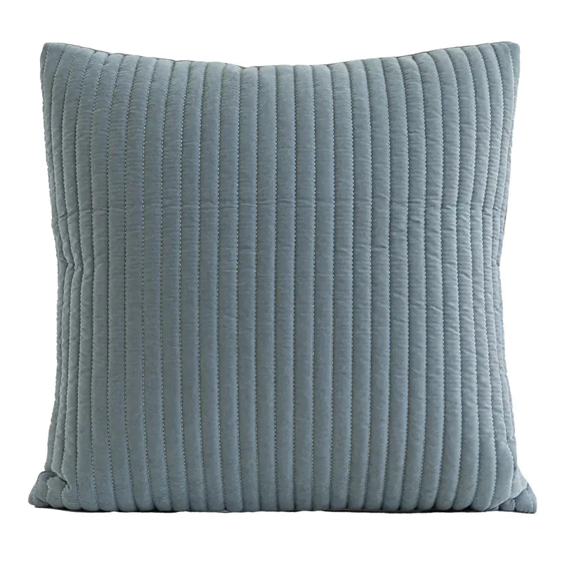 A square throw pillow in a dusty blue-gray color with vertical channel tufting, shown against a plain white background.