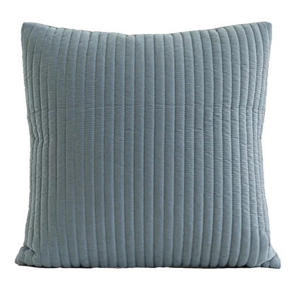 A square throw pillow in a dusty blue-gray color with vertical channel tufting, shown against a plain white background.