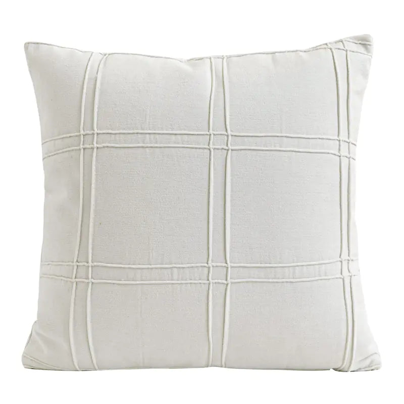 White pillow with grid pattern on a white background